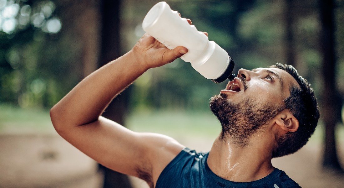 Photo of man drinking from a water bottle