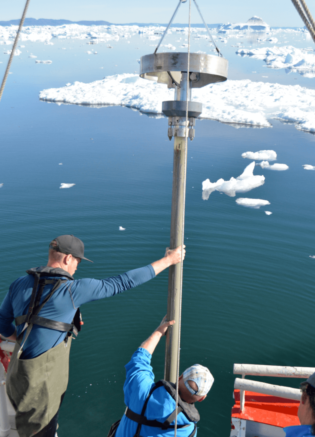 Resaercher are holding a coring instrument on a boat