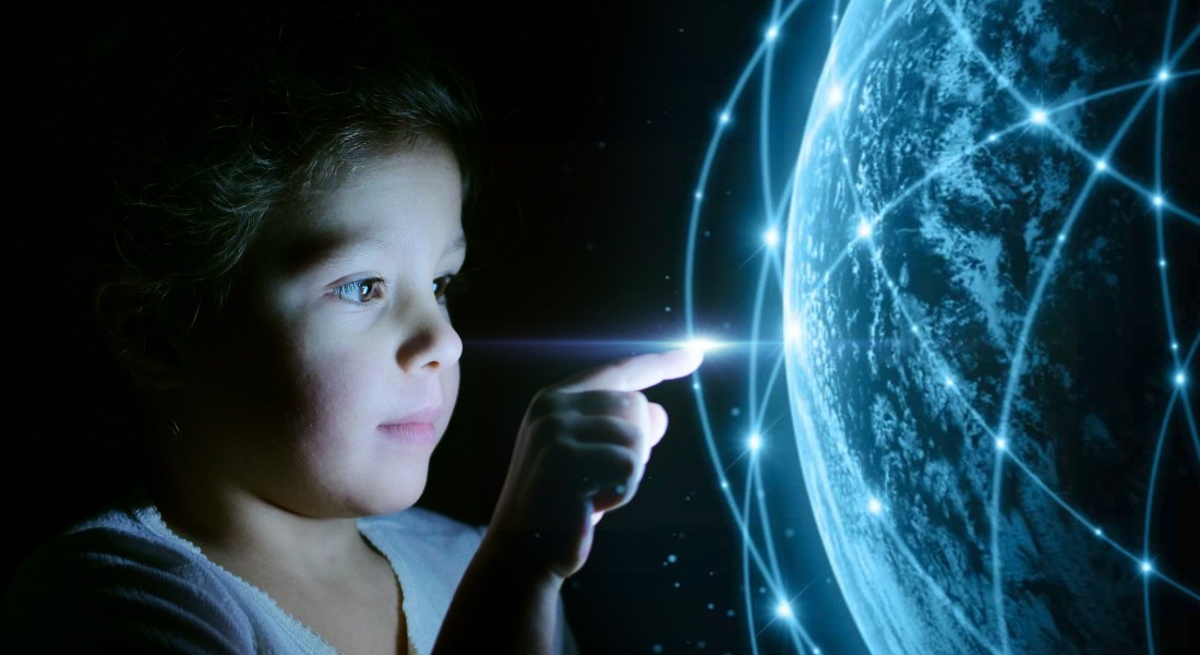 Foto af en dreng, der kigger på jordkloden, der lyser med ny teknologi