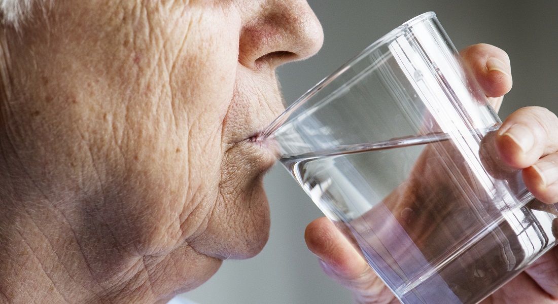 Ældre kvinde drikker vand